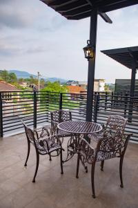 a table and chairs and an umbrella on a patio at Hermitage Boutique House in Taiping