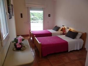 トッサ・デ・マールにあるDanlux Yutaのベッド2台、テーブル、窓が備わる客室です。