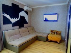 a living room with a couch and two cats sitting on a stool at Apartment on Svobodu ave in Sumy
