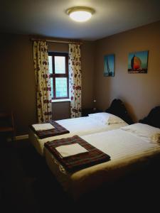 duas camas num quarto de hotel com uma janela em Caitin's em Kells