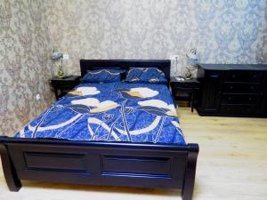 a bedroom with a bed with a blue and white comforter at Apartment on Svobodu ave in Sumy