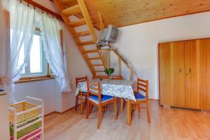 a dining room with a table and chairs and a tv at Apartman Corino in Veli Lošinj