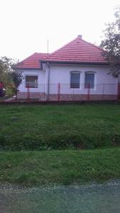 uma casa branca com um telhado vermelho e uma cerca em Haus Sissi em Andocs