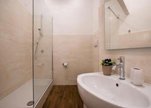 a white bathroom with a sink and a shower at Residenze al Castello in Cagliari +35 photos