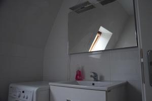 a white bathroom with a sink and a mirror at LEKOMA Pension in Niedergörsdorf