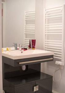 een badkamer met een witte wastafel en een spiegel bij Goélia Les 7 Iles in Perros-Guirec