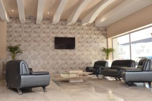 sala de estar con sillas y TV de pantalla plana en Solrand Hotel, en Durban