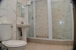 a bathroom with a shower and a toilet and a sink at Solrand Hotel in Durban