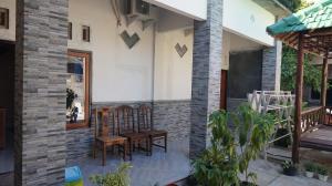 a patio with two chairs on a house at Arriani Homestay in Karimunjawa