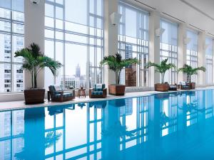芝加哥的住宿－芝加哥半島酒店，棕榈树和窗户的建筑中的游泳池