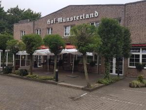 ein Backsteingebäude mit Bäumen davor in der Unterkunft Hotel Hof Münsterland in Ahlen
