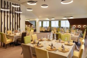 un ristorante con tavoli bianchi e sedie gialle di Belfort Hotel a Braşov