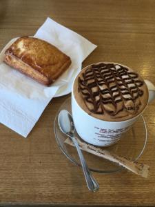 a cup of coffee and a piece of bread on a table at UB Guesthouse & Tours - not for locals in Ulaanbaatar