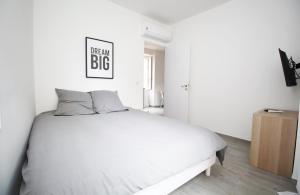 a bedroom with a white bed with a sign on the wall at Republique Garibaldi in Nice