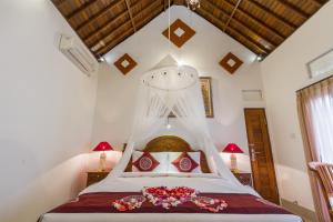 a bedroom with a bed with flowers on it at Jero Sebali Villa in Ubud