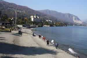 a group of people walking on a beach near the water at Casa Lawrence in Brisino