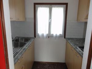 una piccola cucina con lavandino e finestra di Villa Letizia a Bibione