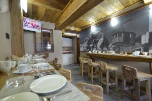 restauracja ze stołami i krzesłami oraz kuchnia w obiekcie Mollino Rooms w mieście Breuil-Cervinia