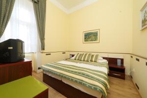 A bed or beds in a room at Hotel Blaha Lujza