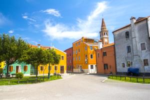 a street with colorful buildings and a church at Locanda Stravedo in Pellestrina