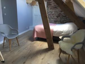 - une chambre mansardée avec un lit et une chaise dans l'établissement B&B Erve ten Dam, à Ambt Delden