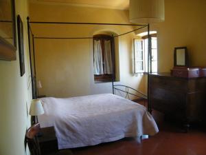 a bedroom with a white bed and a dresser at Villa Il Bosco in Fiesole