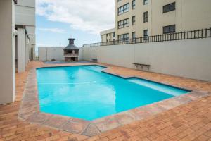 a large blue swimming pool on top of a building at Luxurious Beach Front in Strand