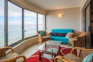 a living room with a couch and chairs and a table at Luxurious Beach Front in Strand