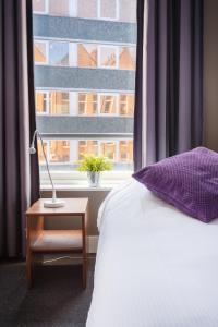 
a bed sitting in front of a window next to a window at Hotel Santa Maria in Rotterdam
