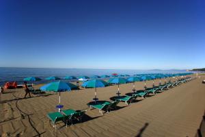 a beach area with umbrellas on the sand at Camping Maremma Sans Souci in Castiglione della Pescaia