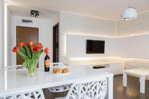 a white kitchen with a vase of flowers and a table at Apartament Moniuszki by Your Freedom in Warsaw