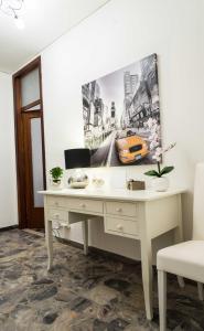 un bureau avec un bureau blanc et une photo sur le mur dans l'établissement Gabrielli Rooms & Apartments - FIERA, à Vérone
