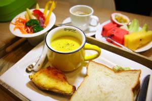 un piatto di cibo con una tazza di zuppa e pane di A-Li A-Li Homestay a Città di Chiayi