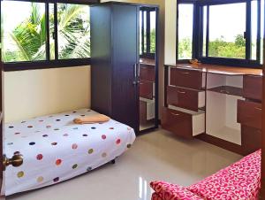 a bedroom with a bed and a kitchen with windows at Sofias House Rental in Tagbilaran City