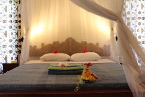 a bed with two pillows and a canopy at Villa Campi Sorga in Senggigi 