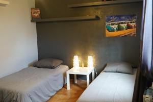 Cette chambre comprend deux lits et une table éclairée. dans l'établissement Appartement Janas , Haut de villa 90m2, à La Seyne-sur-Mer