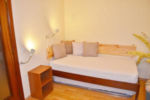 Dormitorio pequeño con cama con sábanas y almohadas blancas en BJB Apartamento, en Olhão