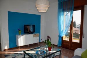 uma sala de estar com televisão e uma parede azul em Appartamento Le Vele em Garda