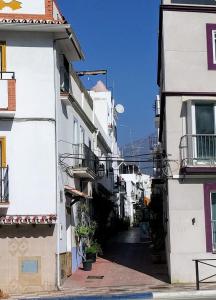 un callejón entre dos edificios en una ciudad en Casa-Casita, en Marbella