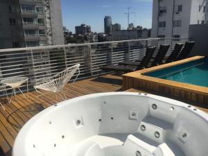 a bath tub sitting on a balcony next to a swimming pool at Departamento en Palermo Soho in Buenos Aires