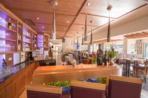 a bar in a restaurant with tables and chairs at Hotel Alpenwelt Superior in Flachau