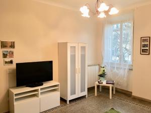 ein Wohnzimmer mit einem TV und einem weißen Schrank in der Unterkunft Casa Francesca in Lucca