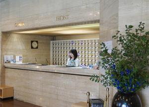 a woman talking on a cell phone in a room at Kurume Station Hotel in Kurume