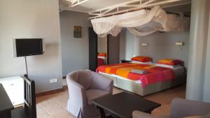 a bedroom with a bed and a tv in a room at Q-Bar & Guesthouse in Dar es Salaam