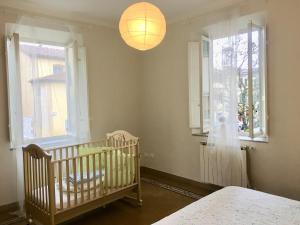 - une chambre avec un lit bébé et 2 fenêtres dans l'établissement Casa Francesca, à Lucques