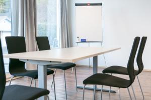 una sala de conferencias con una mesa blanca y sillas en Kinn Hotell Florø, en Florø