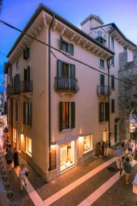 a group of people standing outside of a building at Appartamenti La Grotta in Bardolino