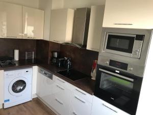 a kitchen with a microwave and a washer and dryer at Apartment Sweet in Hannover