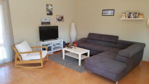 ein Wohnzimmer mit einem Sofa und einem TV in der Unterkunft Casa de Nico in Antigua