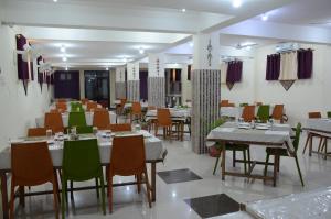 a restaurant with tables and chairs in a room at Hotel Bodh Vilas in Bodh Gaya